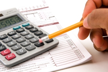 A man doing his taxes using a calculator and pencil on a white background