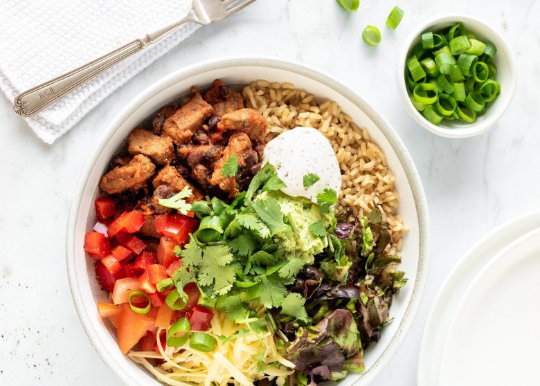 Steak burrito bowl with salad and sour cream