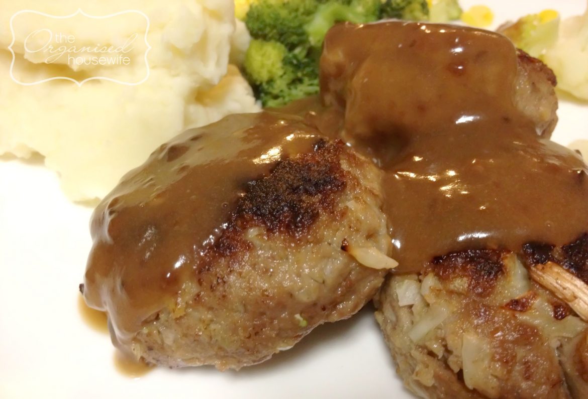 lamb rissoles topped with gravy with a side of vegetable and mash