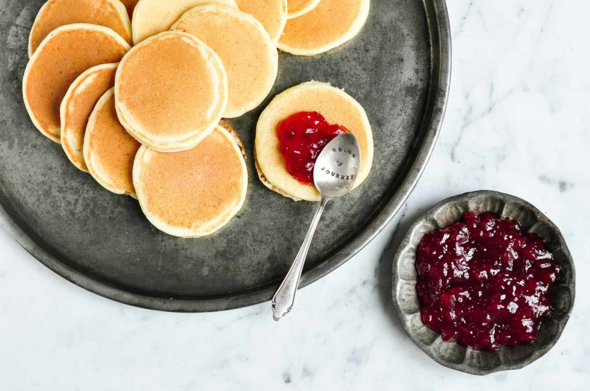 small pikelets with a spoon, doopling raspberry jam